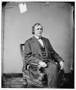 Dr. Rev. JP Newman seated in a chair